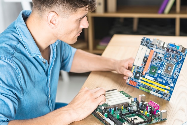 Close-up van de IT-mens die het motherboard-circuit leert