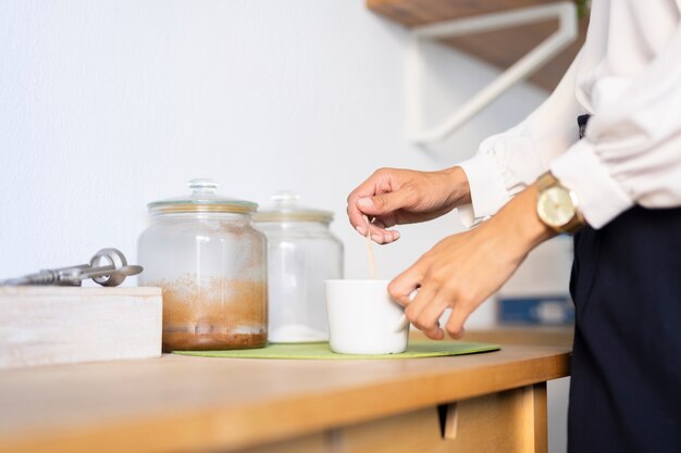 Close-up van de mens die koffie maakt op kantoor