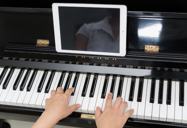 Close-up van de pianist met tablet inoefenen