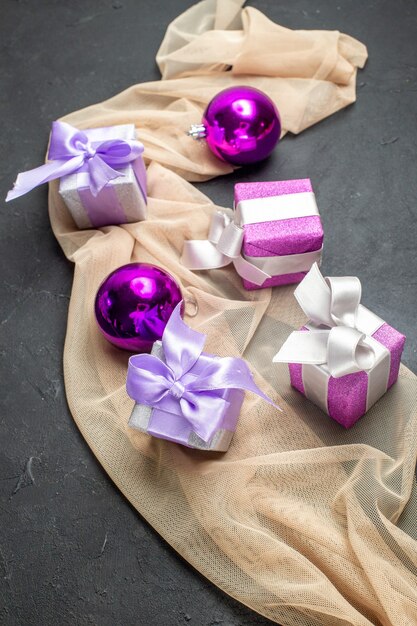 Close-up van de voorkant van kleurrijke geschenken decoratie accessoires voor het nieuwe jaar op naakt kleur handdoek op zwarte achtergrond