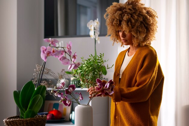 Close-up van de vrouw die haar huis versiert met orchideeën