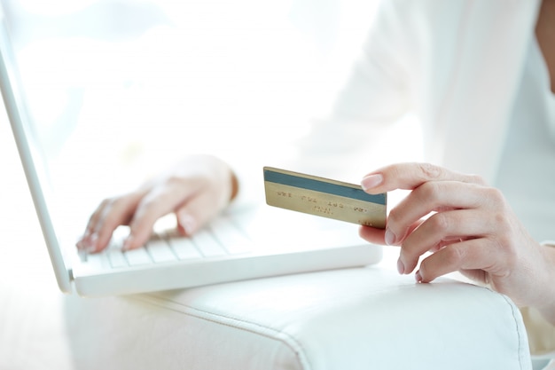 Close-up van de vrouw online winkelen met credit card en laptop
