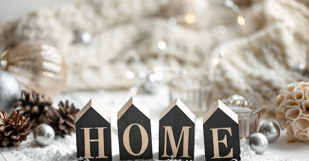 Close-up van decoratief houten woord huis op onscherpe achtergrond met details van kerstvakantie decor.