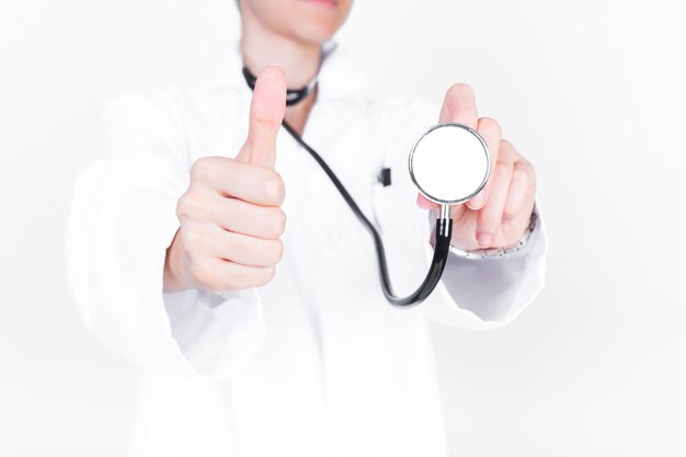 Close-up van een arts met stethoscoop gesturing duimen omhoog