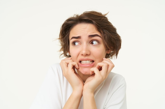 Close-up van een bange brunette vrouw die trilt van angst en er bezorgd en bang uitziet