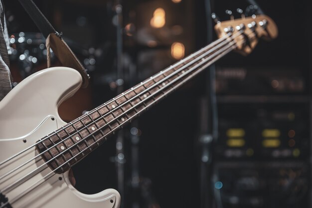 Close-up van een basgitaar in de handen van een muzikant tijdens het spelen.