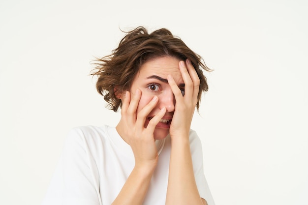 Gratis foto close-up van een brunette vrouw die haar gezicht verbergt, schreeuwt en ziet er bang en geschokt uit door iets