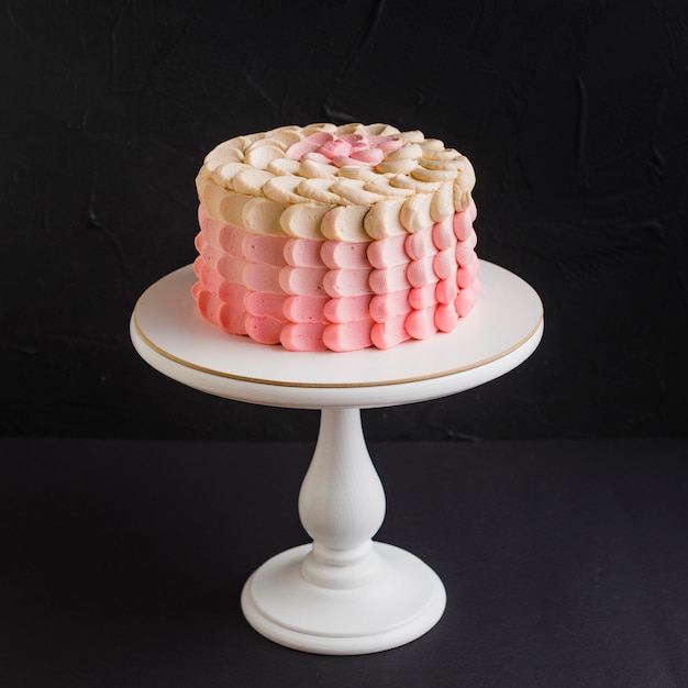 Close-up van een cake op cakestand over zwarte achtergrond