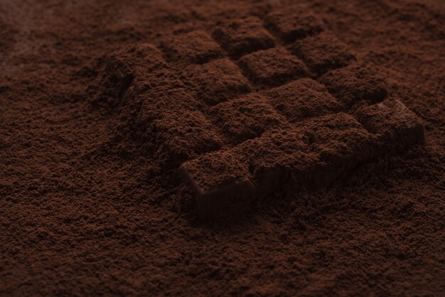 Close-up van een donkere chocoladereep bedekt met chocoladepoeder