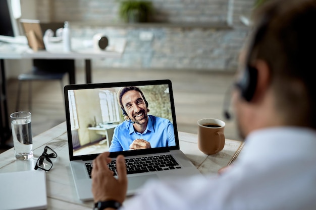 Close-up van een gelukkige ondernemer die een videoconferentie heeft met zijn collega