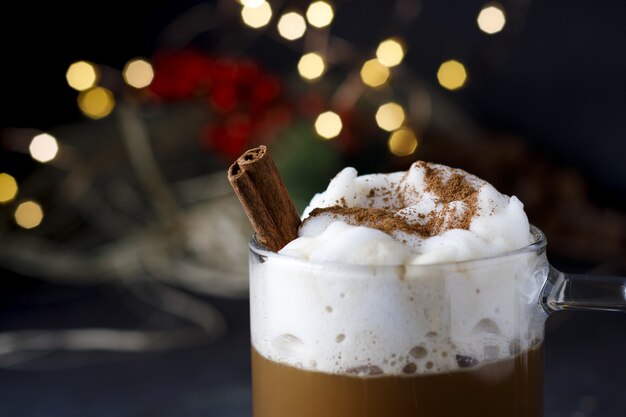 Close-up van een heerlijke koffie van Kerstmis met kaneel en schuim, voor bokehlichten