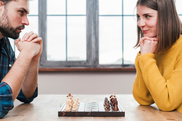 Close-up van een jong koppel met hun hand geklemd kijken naar elkaar schaken