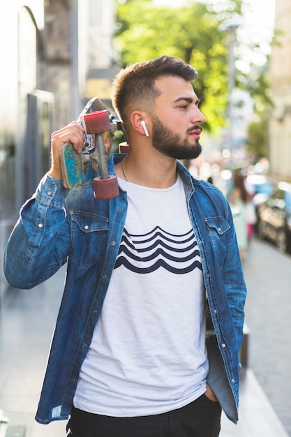 Gratis foto close-up van een jonge man met skateboard