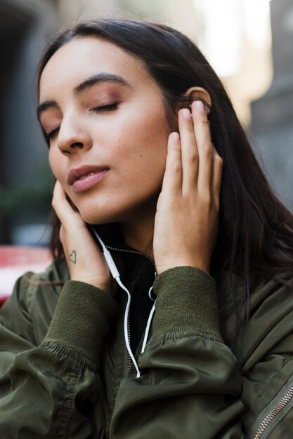 Close-up van een jonge vrouw die van de muziek op oortelefoon geniet