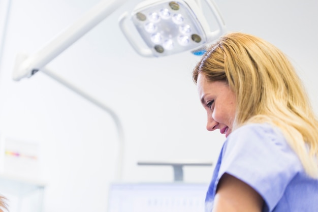 Gratis foto close-up van een jonge vrouwelijke tandarts in de kliniek