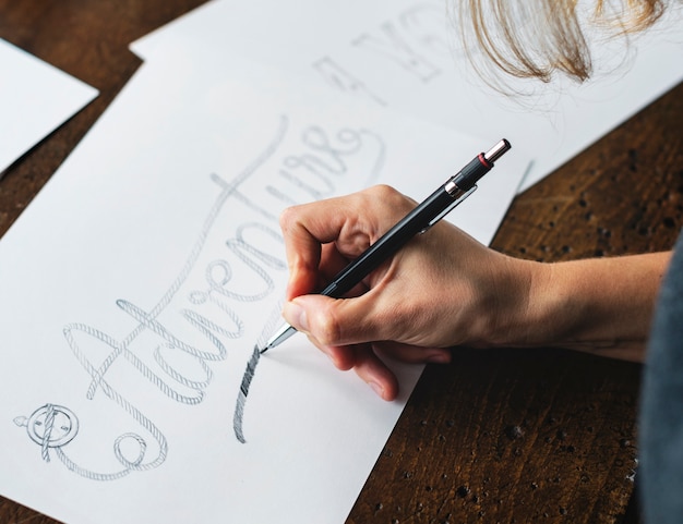 Close-up van een kalligraaf die aan een project werkt