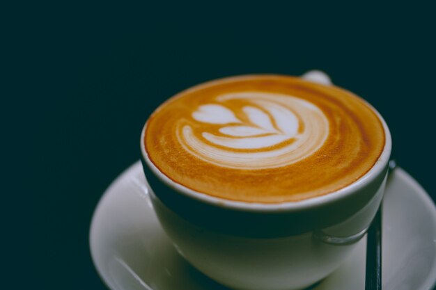 Close-up van een kopje heerlijke latte op een schotel
