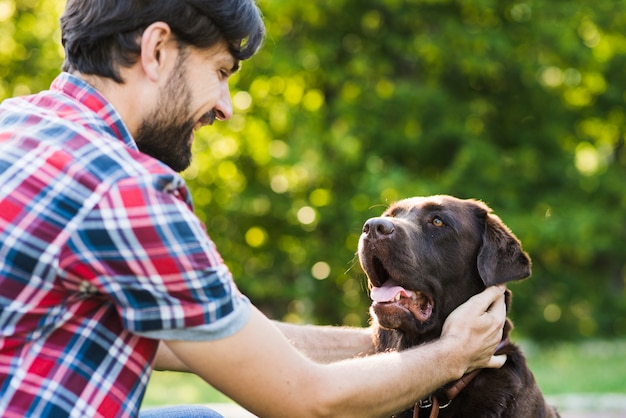 Close-up van een man die zijn hond aait