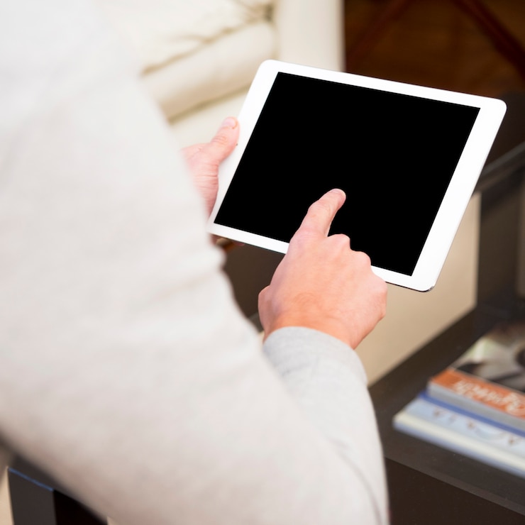 Gratis Foto close-up van een man hand wat betreft de digitale tablet met vinger