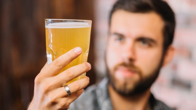 Close-up van een man&#39;s hand met een glas bier