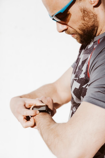 Close-up van een mens die slim horloge draagt ​​tegen witte achtergrond