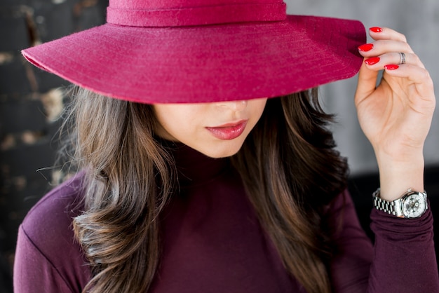 Close-up van een mooie jonge vrouw met roze hoed