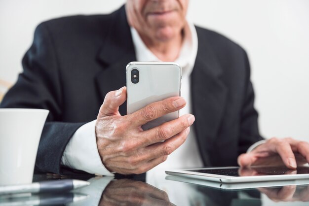 Close-up van een oudere man slimme telefoon in de hand te houden