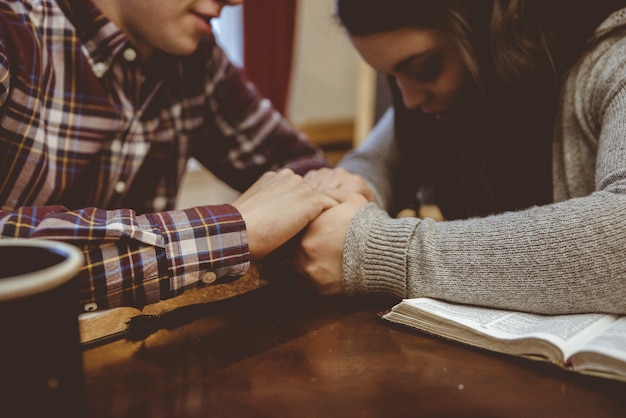 Close-up van een paar hand in hand op de tafel