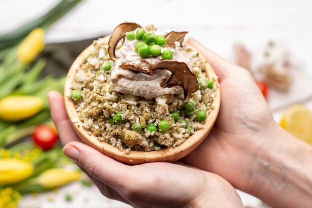 Close-up van een persoon die een kom heerlijke veganistische salade houdt