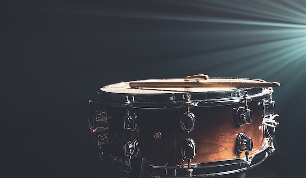 Close-up van een snaredrum, percussie-instrument op een donkere achtergrond met prachtige verlichting, kopieerruimte.