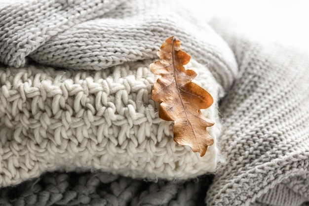 Gratis foto close-up van een stapel gebreide truien met herfstbladeren