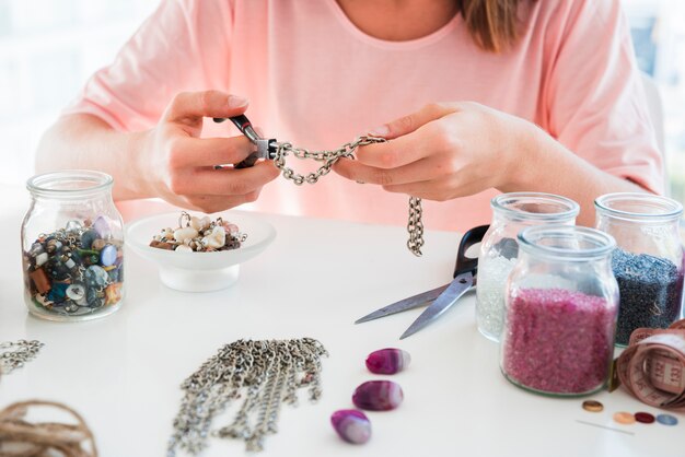 Close-up van een vrouw die de handgemaakte armband met ketting en kralen