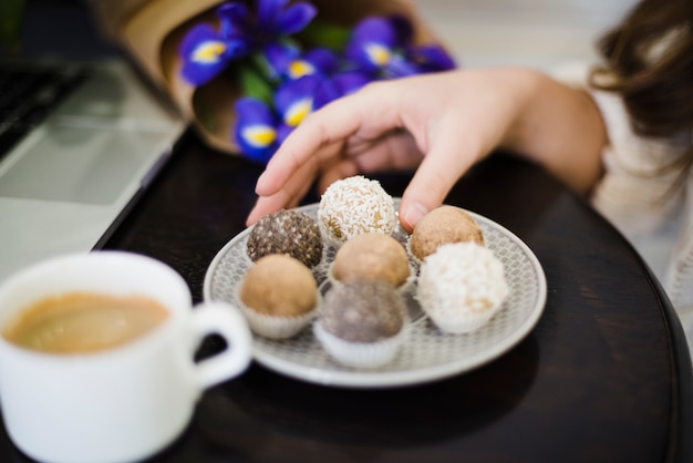 Close-up van een vrouw die verschillend type van truffels op plaat eet