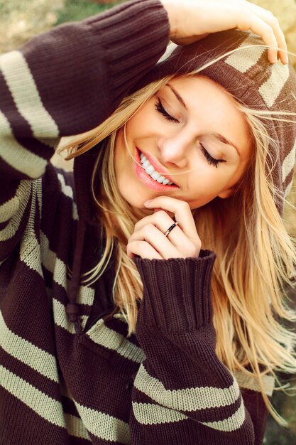 Close-up van een vrouw met een grote glimlach het dragen van een gestreepte trui