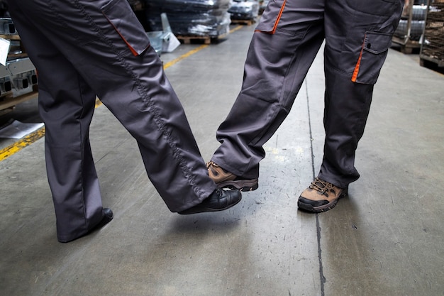 Gratis foto close-up van fabrieksarbeiders aanraken met benen en begroeting vanwege coronavirus en infectie