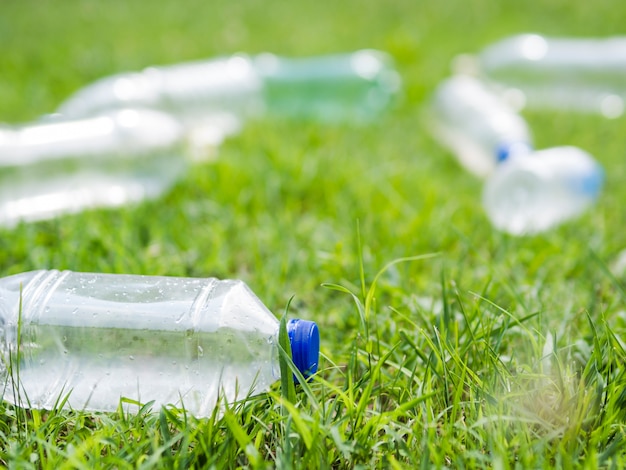 Gratis foto close-up van fles van het afval de plastic water op gras bij park