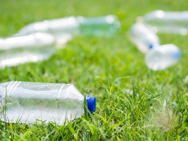 Close-up van fles van het afval de plastic water op gras bij park