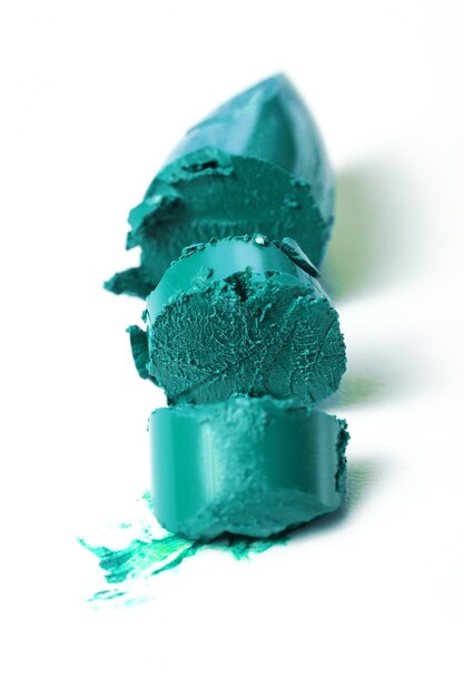 Close-up van gebroken mooie turkooise groene lippenstift. Mode. Heldere achtergrond.