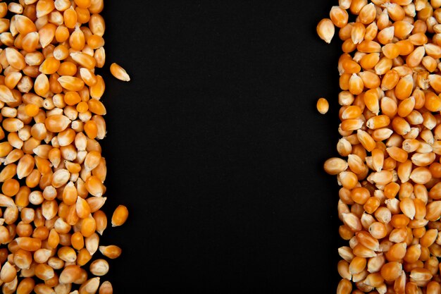 Close-up van gedroogde maïs zaden aan de linker- en rechterkant en een zwarte achtergrond met kopie ruimte