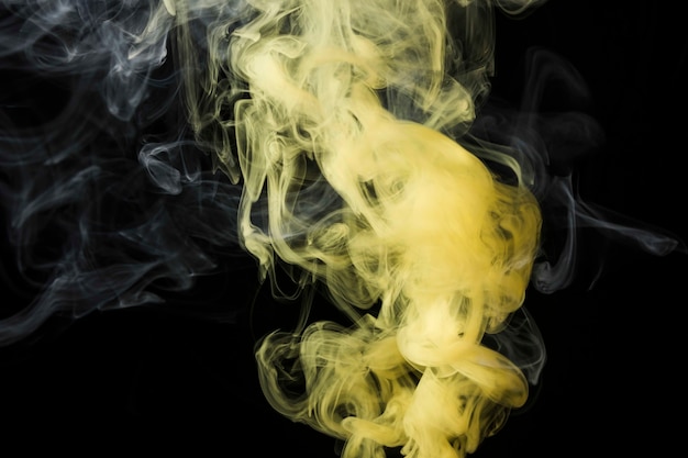 Close-up van gele rook tegen zwarte achtergrond