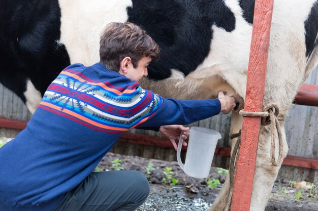 Close-up van gelukkige man het melken van een melkkoe