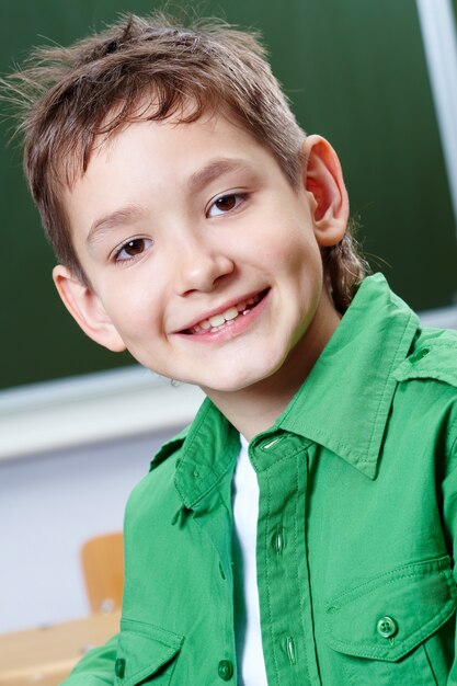 Close-up van glimlachende kleine jongen met groen shirt