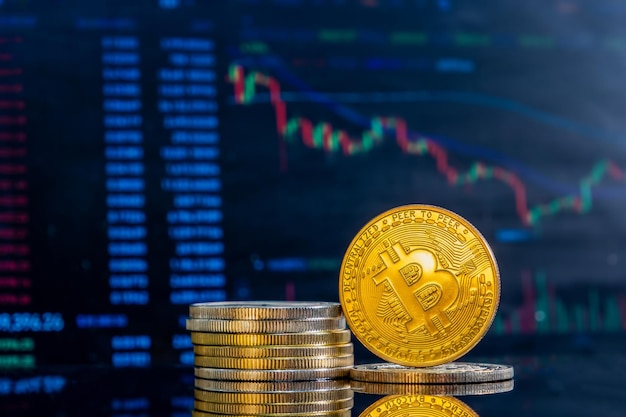 Close-up van gouden Bitcoins op een donker reflecterend oppervlak en het histogram van afnemende crypto