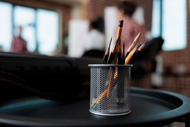Close-up van grafische potloden staan op tafel in de studio van de creativiteitsschool. In achtergrond diverse teamtekening vaasschets op canvas die bij het schetsen van techniek werken. Goede voornemens