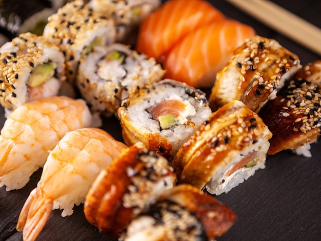 Close up van heerlijke verse sushi op zwarte plaat