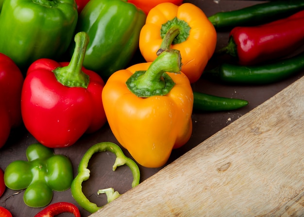 Close-up van hele en gesneden paprika's met snijplank