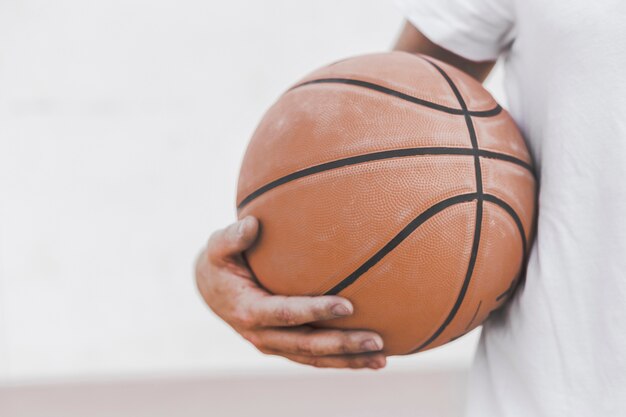 Close-up van het basketbal van de de handholding van een mannelijke speler