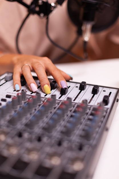 Close-up van het controleren van geluid met mixer tijdens podcast
