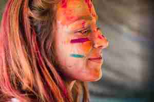 Gratis foto close-up van het gezicht van de vrouw bedekt met holi kleur