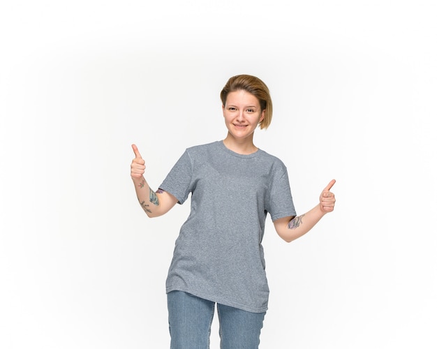 Close-up van het lichaam van de jonge vrouw in lege grijze t-shirt die op witte ruimte wordt geïsoleerd. Bespotten voor ontwerpconcept